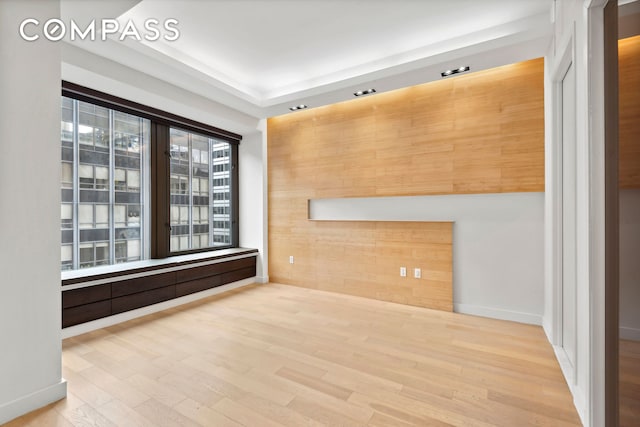 spare room with wood finished floors and wooden walls