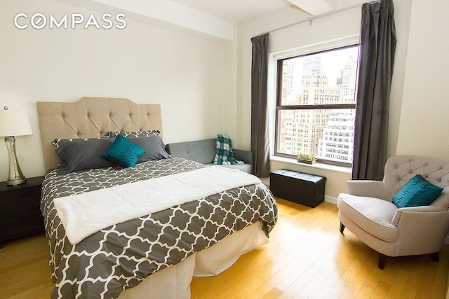 bedroom with multiple windows and wood finished floors