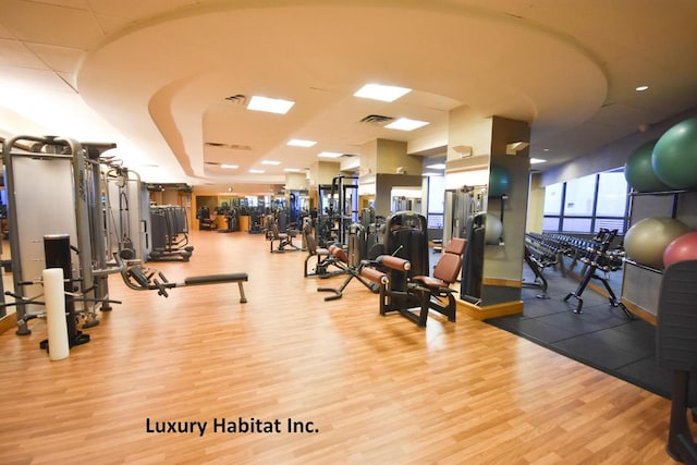 exercise room with visible vents and light wood-style flooring