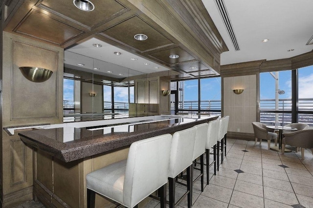 bar with coffered ceiling, pendant lighting, light tile patterned flooring, and plenty of natural light