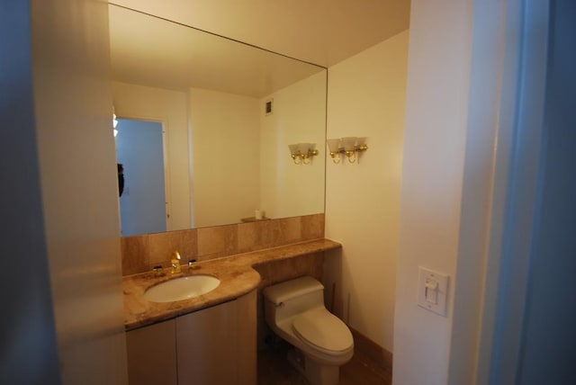 bathroom with visible vents, vanity, and toilet