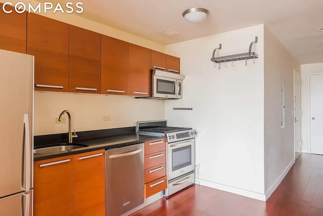 kitchen with stainless steel appliances, dark hardwood / wood-style floors, and sink