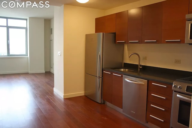 kitchen featuring sink, dark wood-type flooring, and appliances with stainless steel finishes