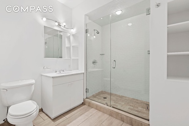 bathroom featuring walk in shower, vanity, and toilet