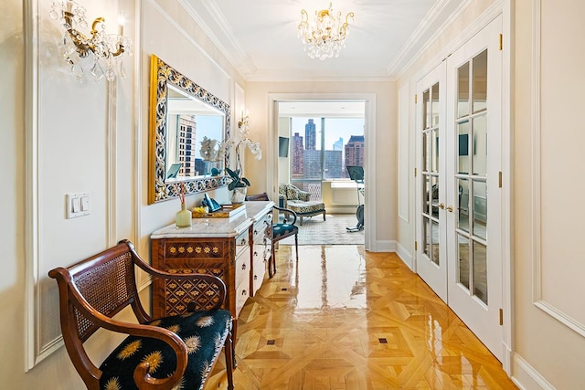 hallway featuring crown molding, baseboards, french doors, an inviting chandelier, and a view of city