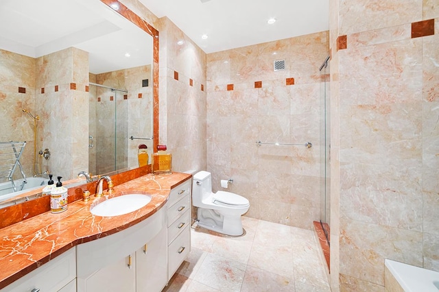 full bathroom featuring visible vents, toilet, vanity, a stall shower, and tile walls