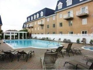 view of pool with a community hot tub and a patio area