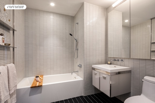 bathroom featuring tile walls, toilet, shower / tub combination, recessed lighting, and vanity