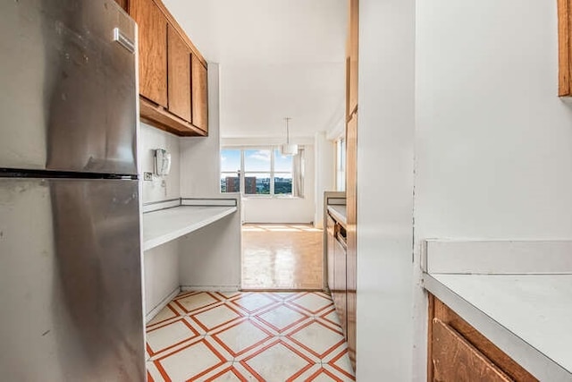 kitchen with stainless steel fridge and hanging light fixtures