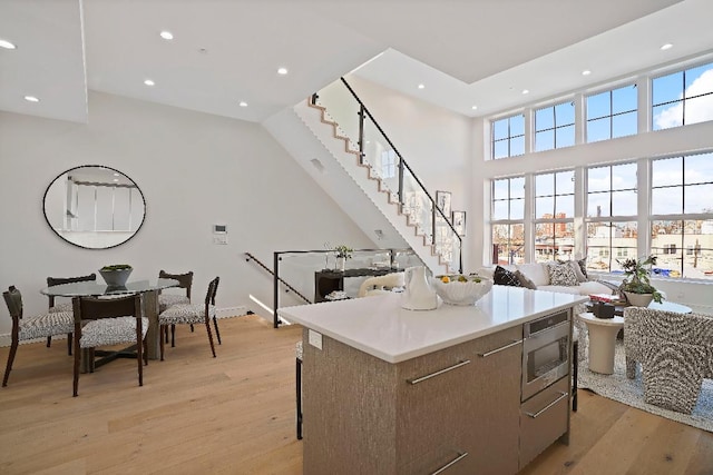 kitchen with light hardwood / wood-style floors, stainless steel microwave, and a center island