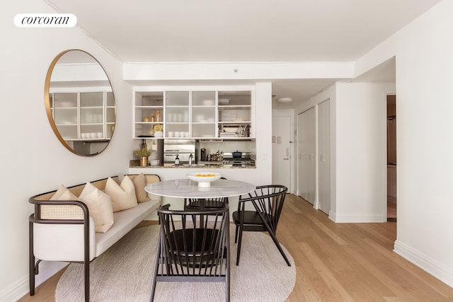 dining area with light wood finished floors, visible vents, and baseboards