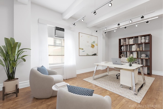 office area featuring a wall unit AC, rail lighting, baseboards, and wood finished floors