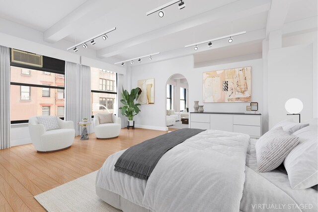 bedroom with track lighting and light wood-type flooring