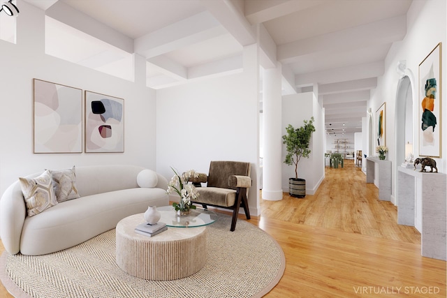 living area with wood finished floors, beam ceiling, and baseboards