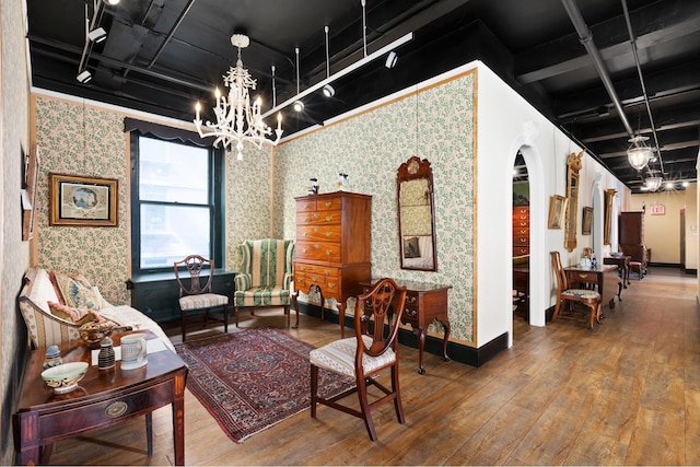 interior space with arched walkways, hardwood / wood-style floors, a chandelier, and wallpapered walls