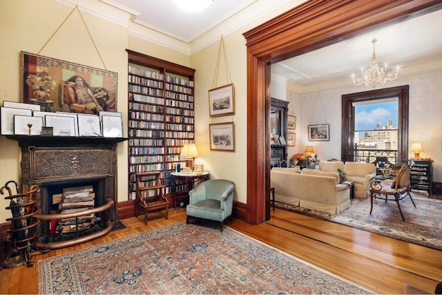 sitting room featuring crown molding, a chandelier, and hardwood / wood-style floors