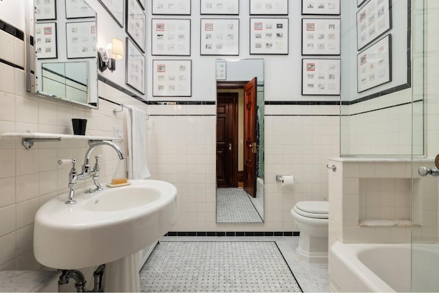 bathroom featuring tile patterned floors, sink, tile walls, toilet, and a bathing tub