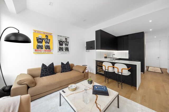 living room with light wood-type flooring, beverage cooler, and recessed lighting