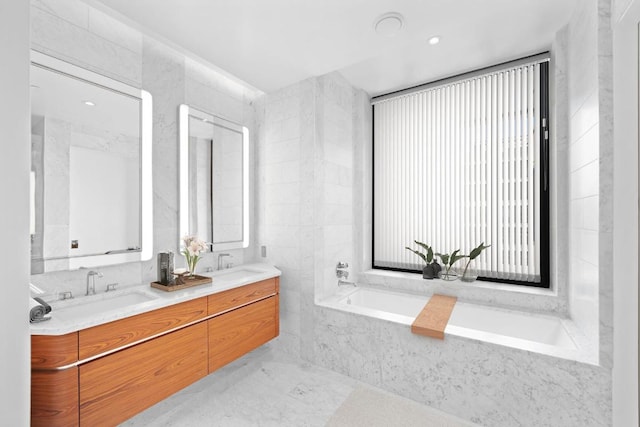 bathroom with vanity, tiled bath, and tile walls