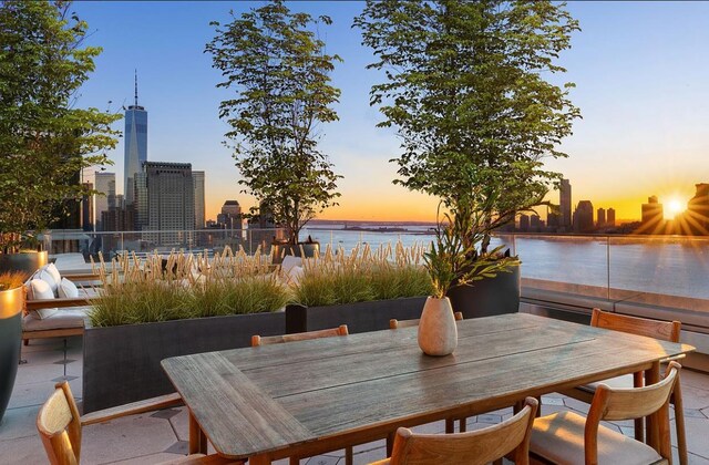 110 Charlton St Unit Ph30C, New York City, NY 10014 - patio terrace at dusk featuring a water view, a view of city, and outdoor dining area