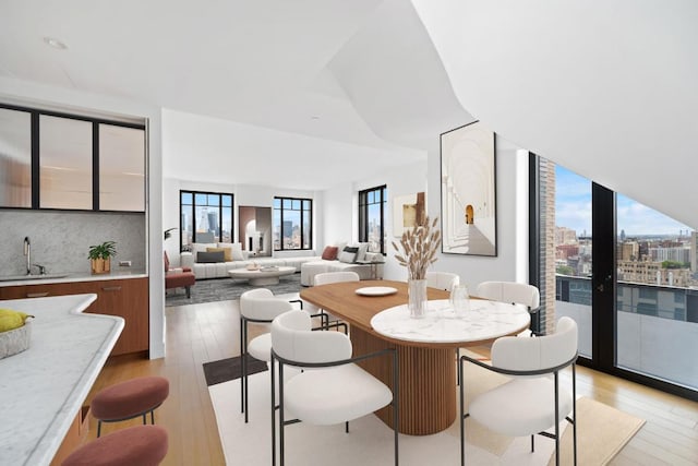 dining area with sink and light hardwood / wood-style floors