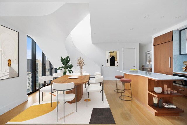 dining room with floor to ceiling windows and light hardwood / wood-style floors