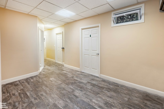 basement with baseboards, a drop ceiling, and wood finished floors