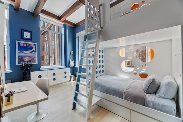 bedroom with wood finished floors and beam ceiling