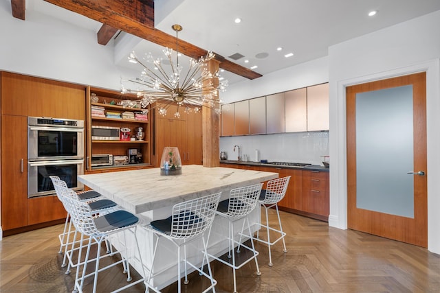 kitchen with a chandelier, appliances with stainless steel finishes, a breakfast bar area, and a kitchen island