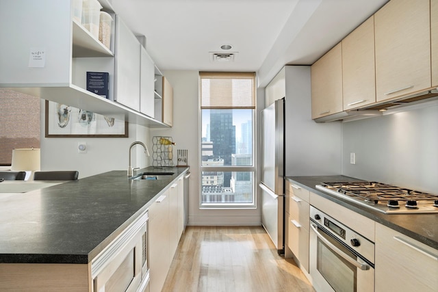 kitchen featuring open shelves, stainless steel appliances, visible vents, light wood-style floors, and a sink