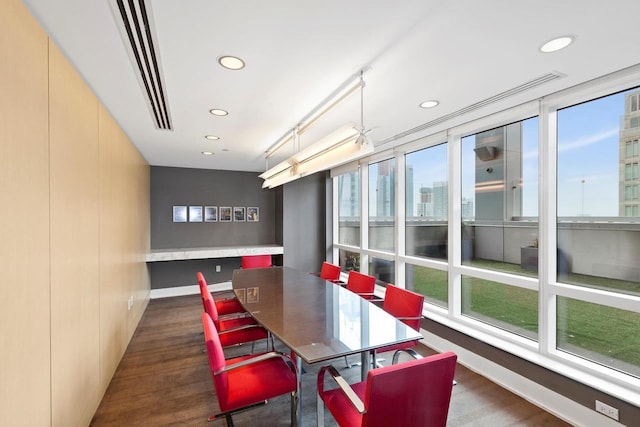 dining area with recessed lighting, baseboards, a city view, and wood finished floors