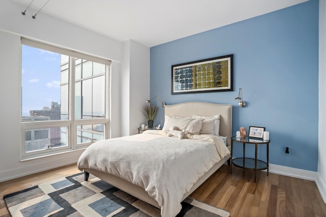 bedroom featuring wood finished floors and baseboards