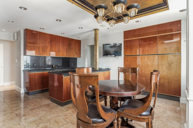 303 E 57th St Unit 45G, New York City, NY 10022 - kitchen with dark countertops, tasteful backsplash, a chandelier, modern cabinets, and recessed lighting