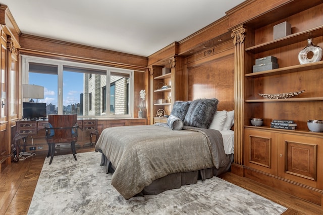 bedroom with wood finished floors and ornamental molding