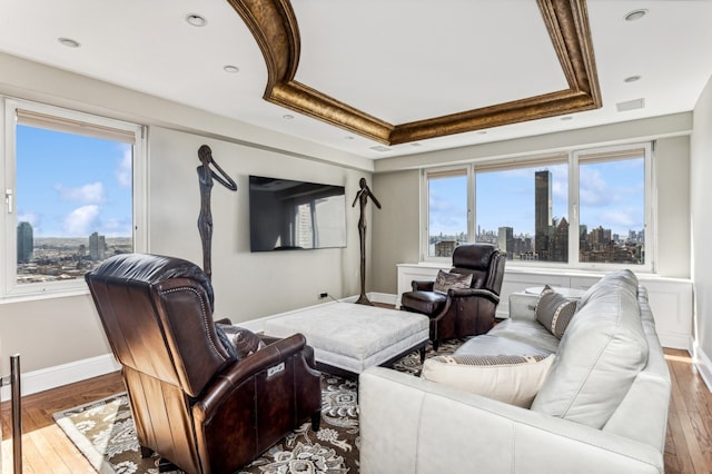 living room with hardwood / wood-style floors, a raised ceiling, and visible vents