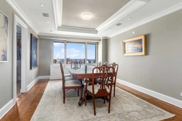 dining area featuring ornamental molding, a tray ceiling, wood finished floors, recessed lighting, and baseboards