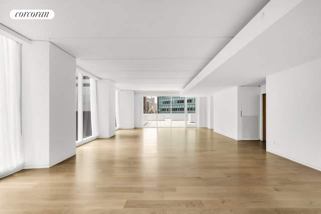 unfurnished living room featuring light hardwood / wood-style flooring and floor to ceiling windows