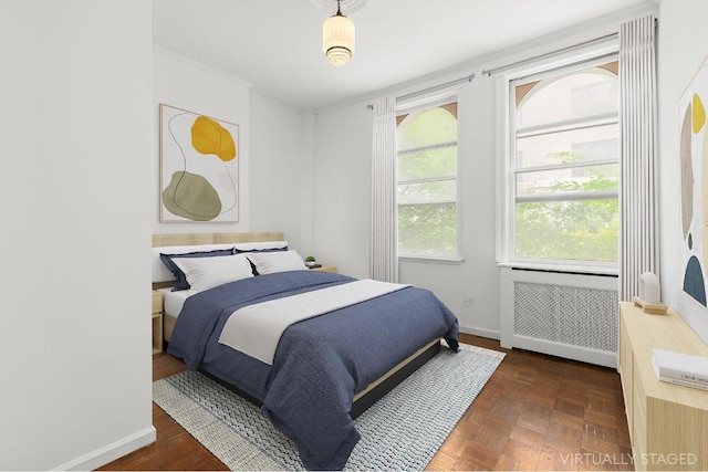 bedroom featuring radiator heating unit and dark parquet floors