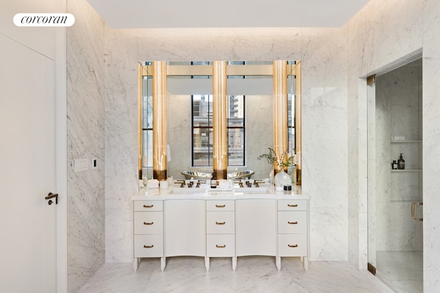 bathroom featuring marble finish floor, a marble finish shower, vanity, and tile walls