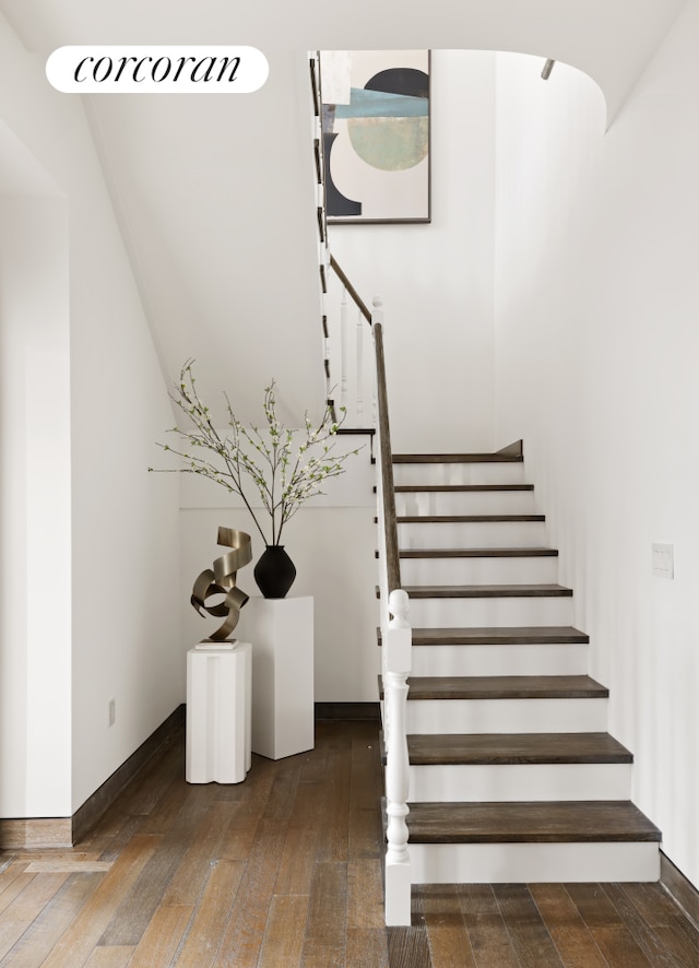 stairway featuring hardwood / wood-style floors and baseboards