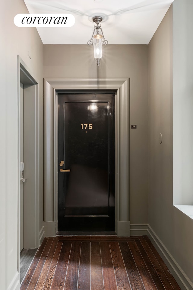 doorway to outside with dark wood-style floors and baseboards