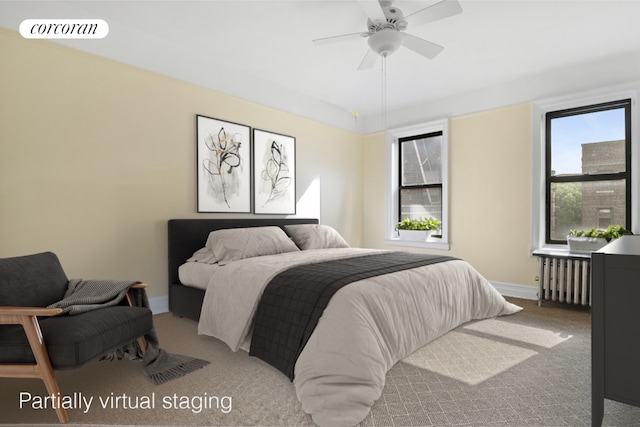 bedroom featuring ceiling fan, multiple windows, radiator heating unit, and carpet floors