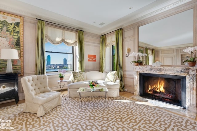 living area featuring crown molding and a high end fireplace