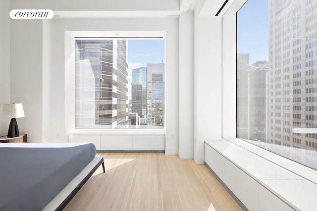 bedroom featuring light wood-style flooring and a view of city