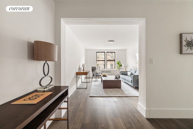 corridor with radiator heating unit and dark hardwood / wood-style floors