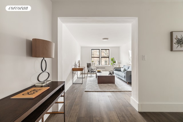 interior space featuring radiator heating unit, dark wood-style flooring, visible vents, and baseboards