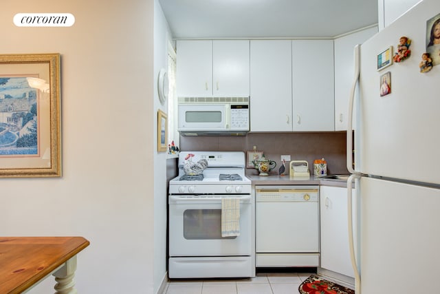 kitchen featuring white cabinetry, light tile patterned floors, and white appliances