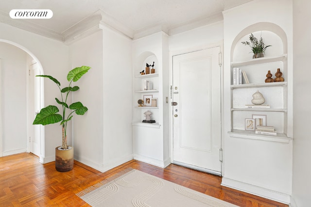 foyer featuring ornamental molding and parquet floors