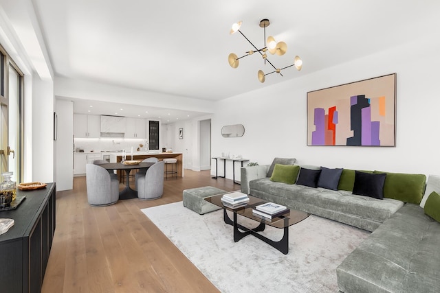 living room with recessed lighting, light wood finished floors, and a notable chandelier