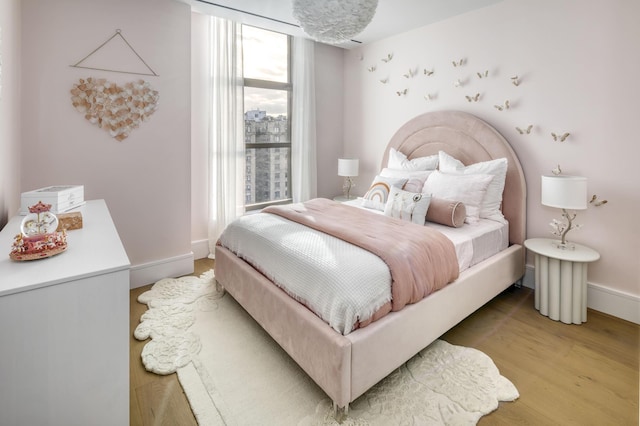 bedroom featuring light wood-type flooring and baseboards